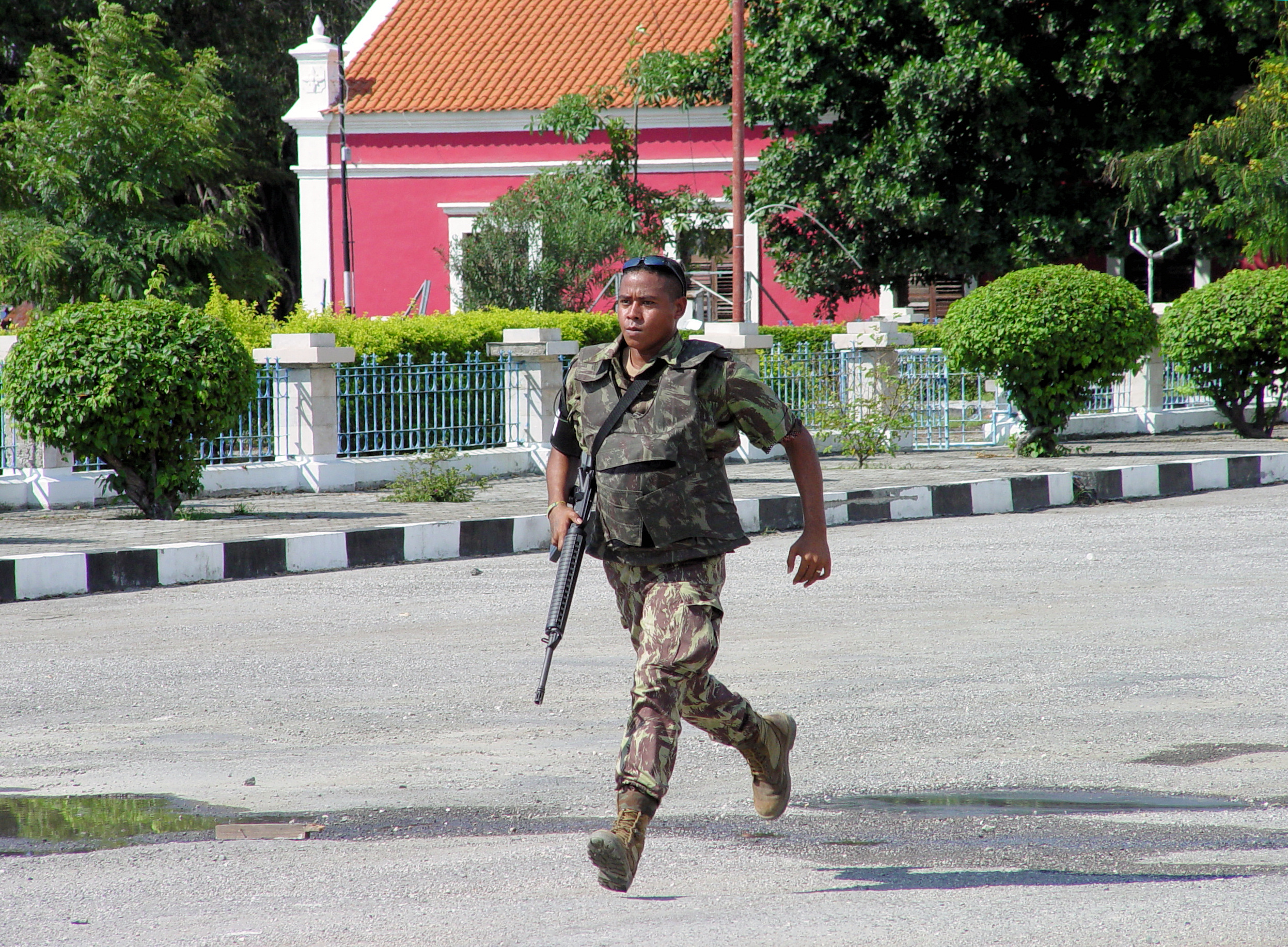 CLICK HERE - Soldier runs through downtown Dili street